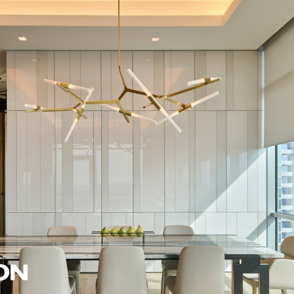Modern dining room with a sculptural chandelier, glass dining table, upholstered chairs, and large windows with automated window shades, featuring Lutron lighting control branding.